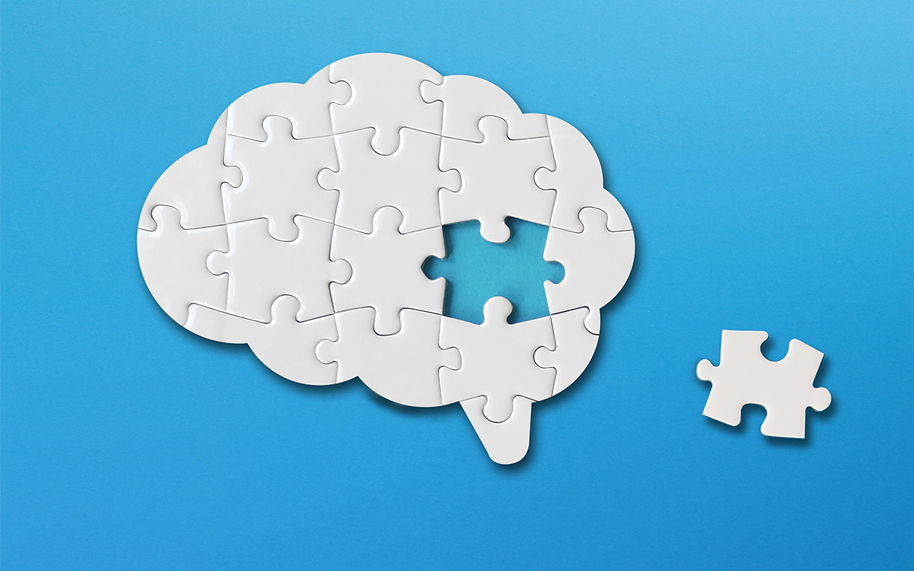 Brain shaped white jigsaw puzzle on blue background, a missing piece of the brain puzzle, mental health and problems with memory.