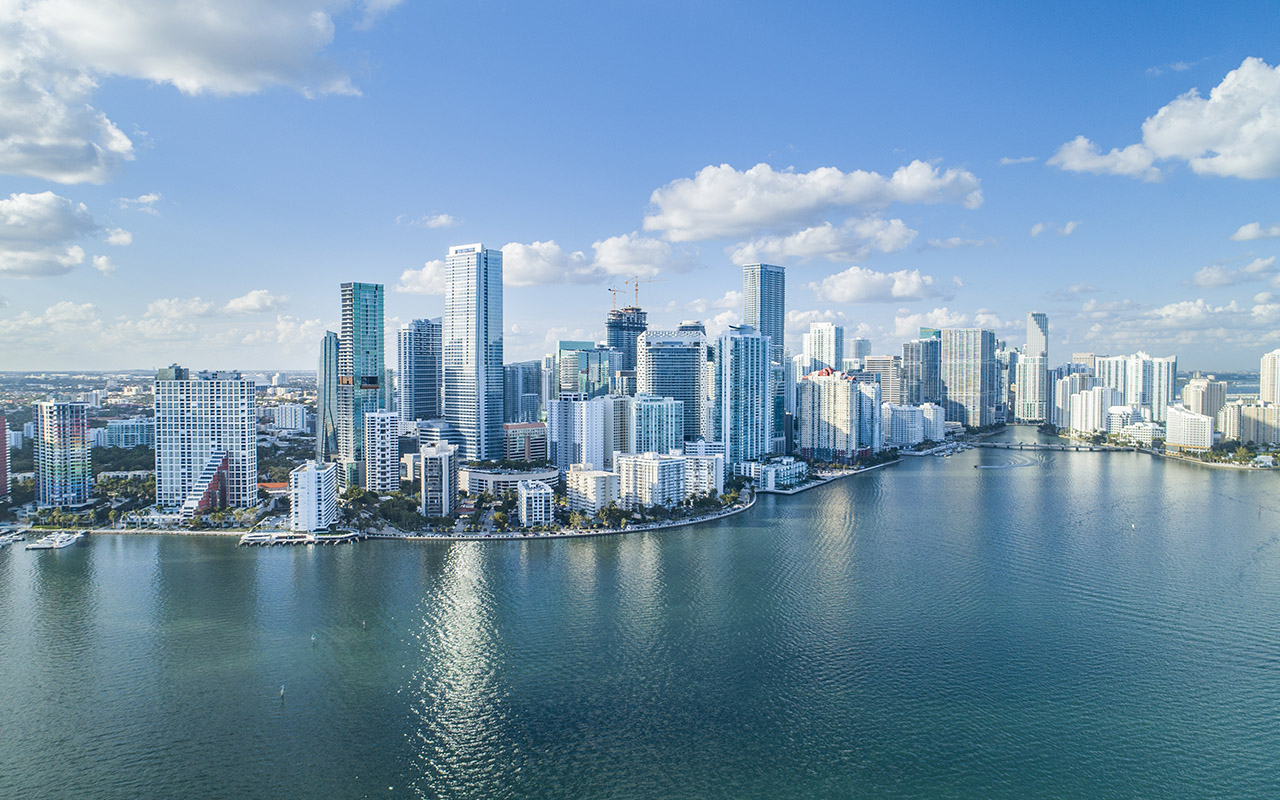 A landscape photo of Miami with a slightly cloudy sky.