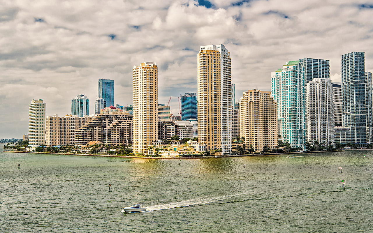 Miami skyline skyscrapers with yacht or boat sailing next to Miami downtown.