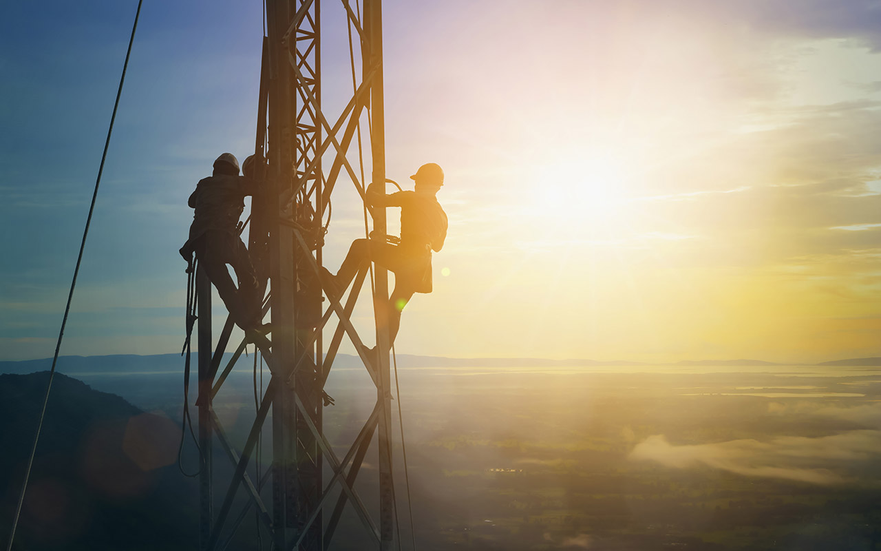 Silhouette electrician work on high ground heavy industry concept. Construction of the extension of high voltage in high voltage stations safely and systematically over blurred natural background. - stock photo