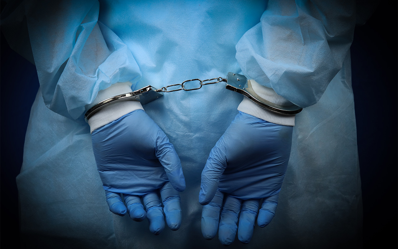 Image of doctor handcuffed, hands close-up
