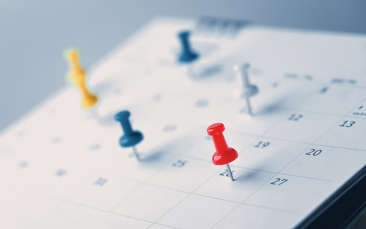 Calendar with color push pins on it