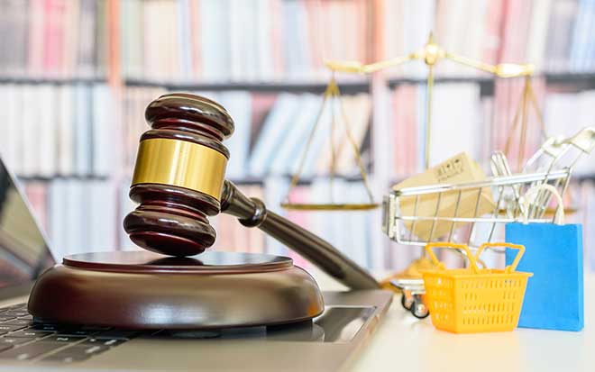 Gavel on a laptop with bookcase in the background