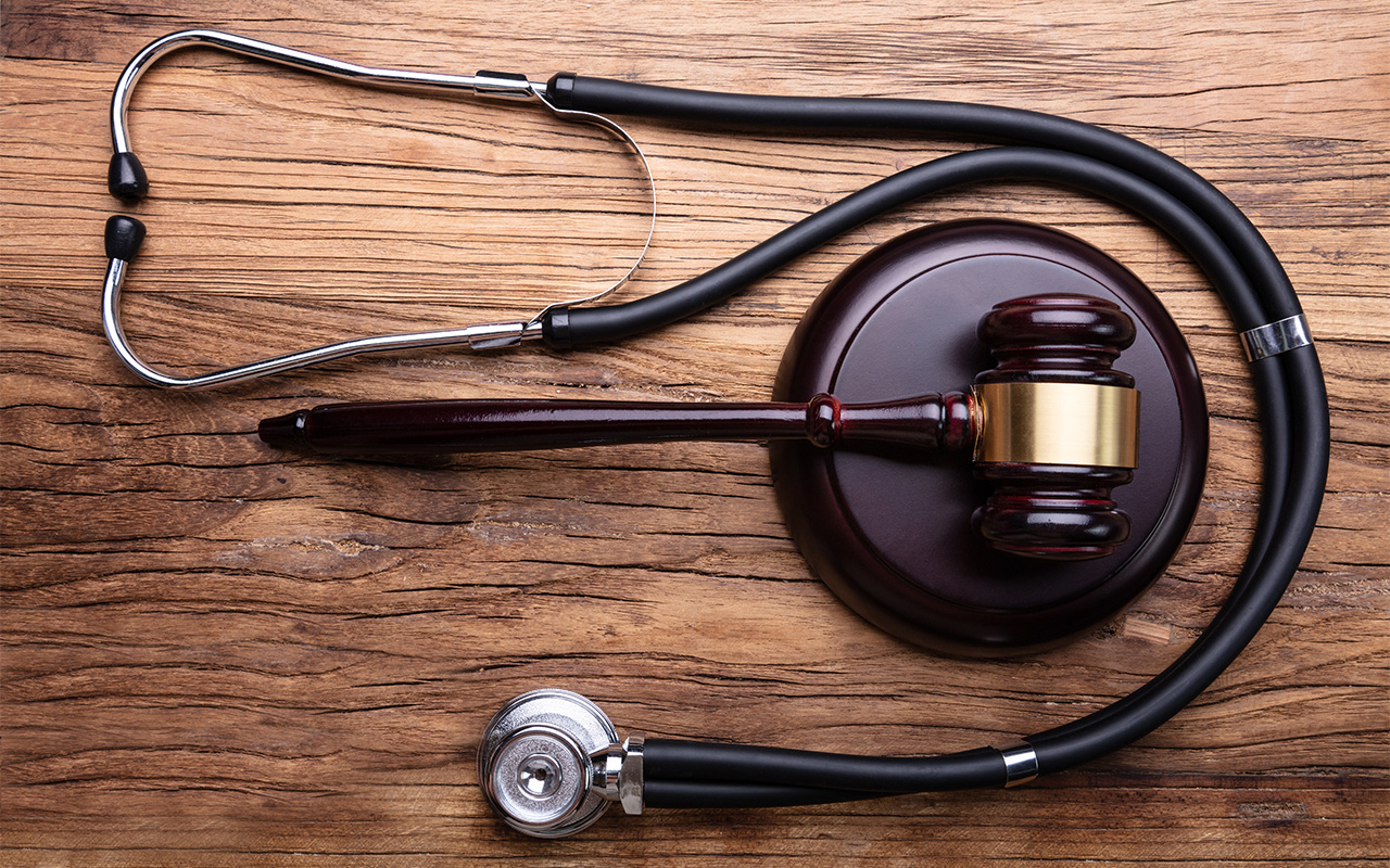 High Angle View Of Gavel With Stethoscope Arranged On Wooden Table
