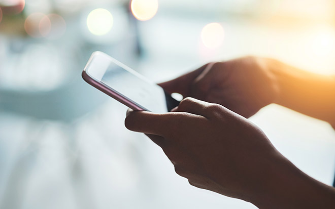 Hands holding and operating a smartphone