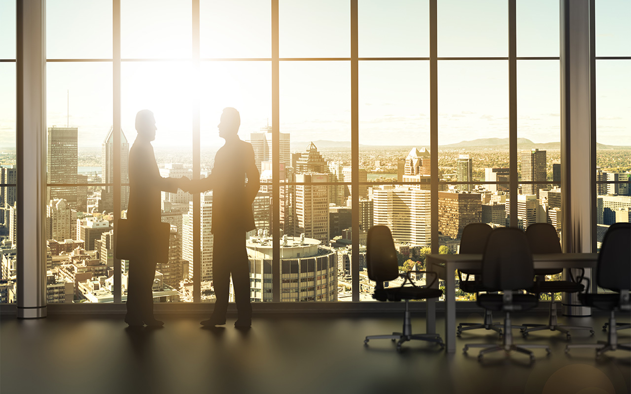 image of two men shaking hands in front on office highrise window