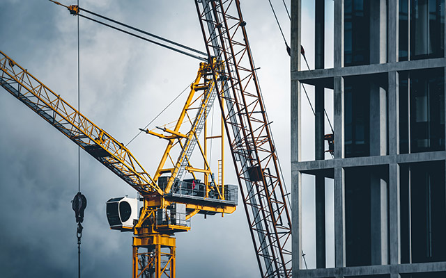 Construction site with cranes lowering supplies on a building