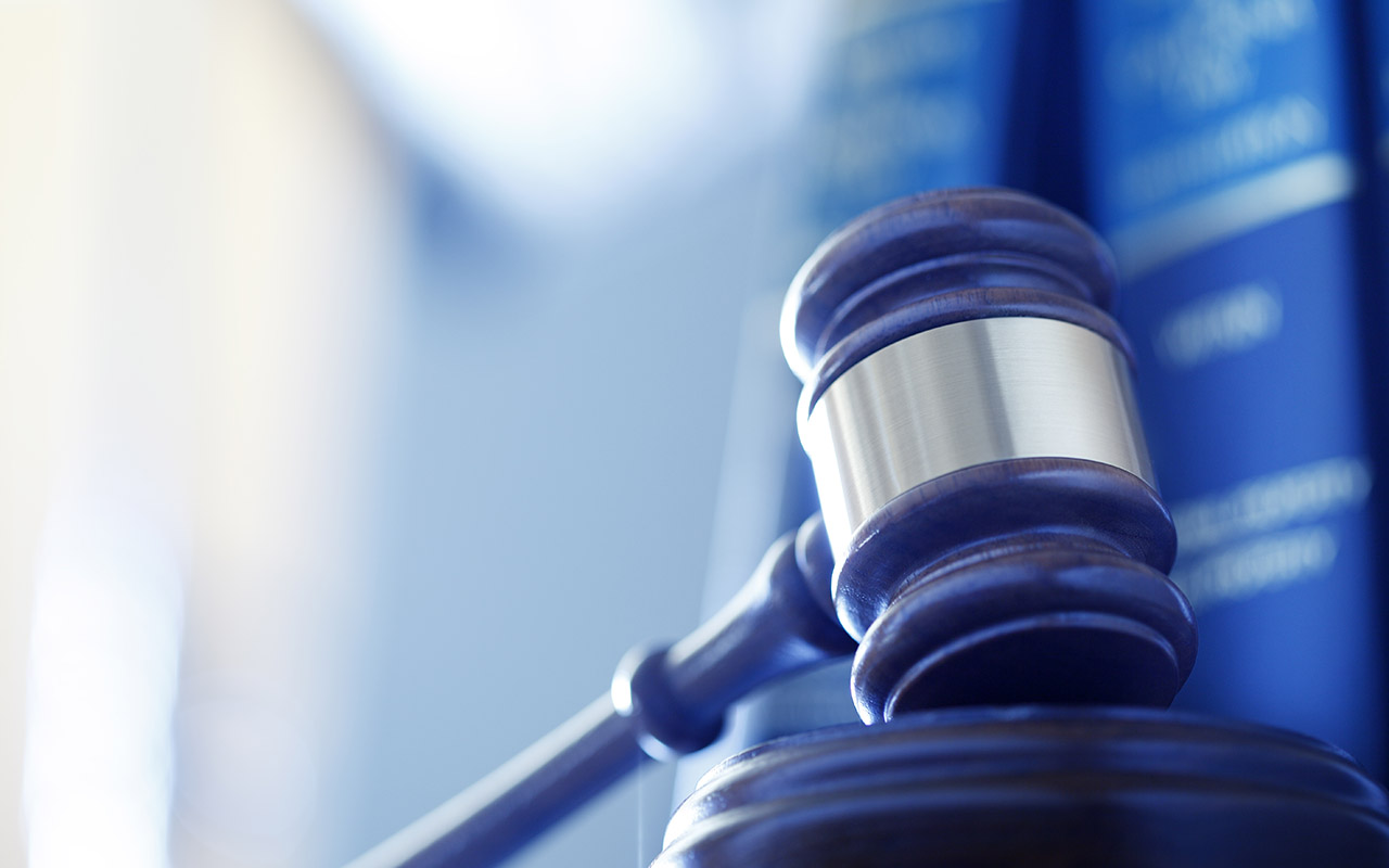 Photo of a gavel with books in the background