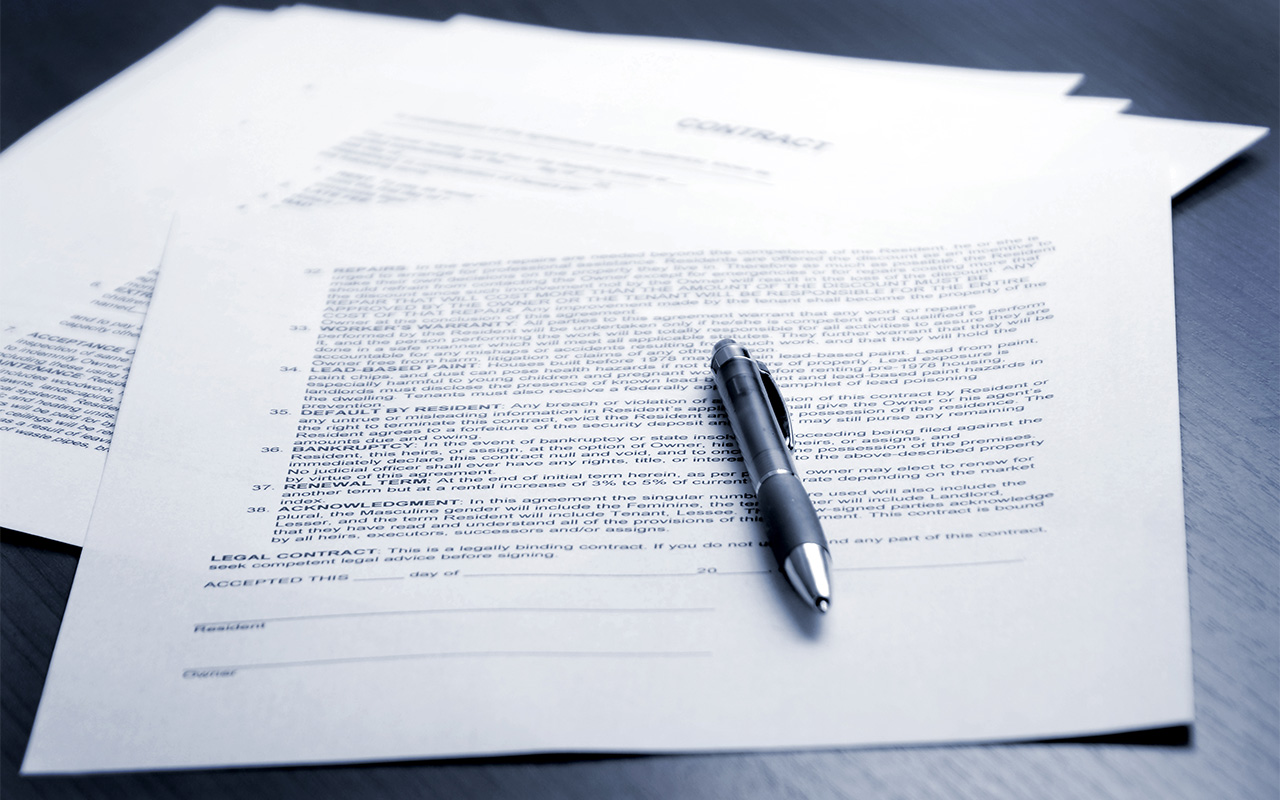 photo illustration of a contract and a pen for signing
