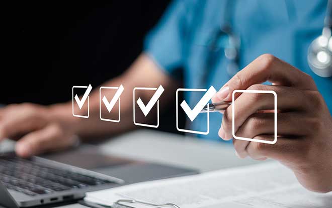 photo of a physician at a computer tapping a digital check box with a pen