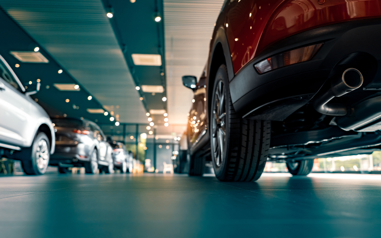 A line of cars inside of a dealership show room.