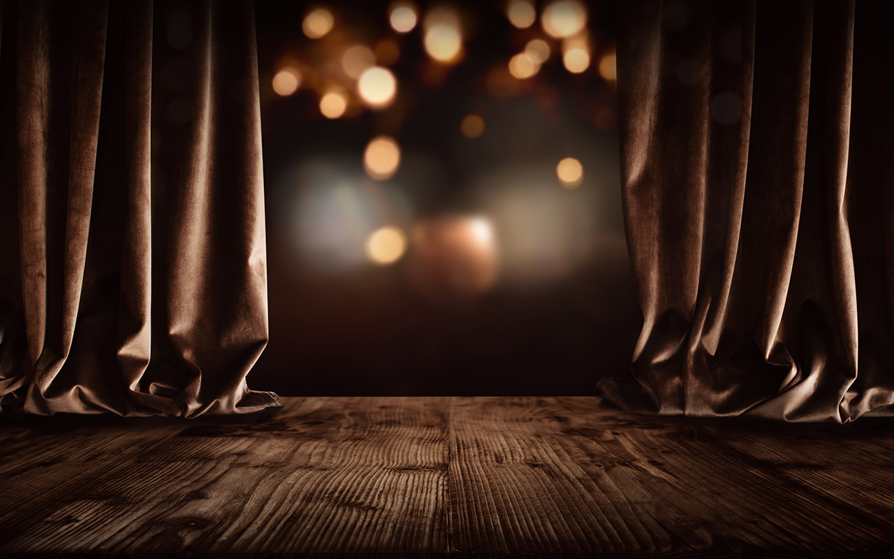 A photo of a stage with the curtains partially open.