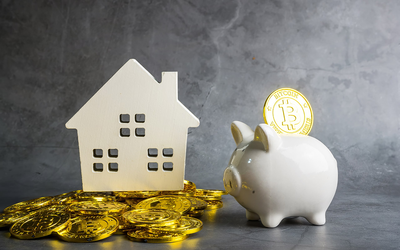 Illustration of Bitcoin money with piggy bank and wooden home model on the table.