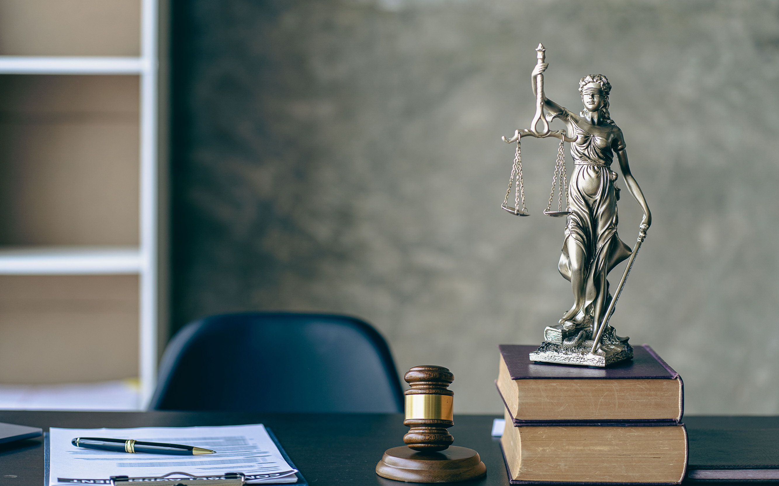 Photo of book with statue and gavel on desk