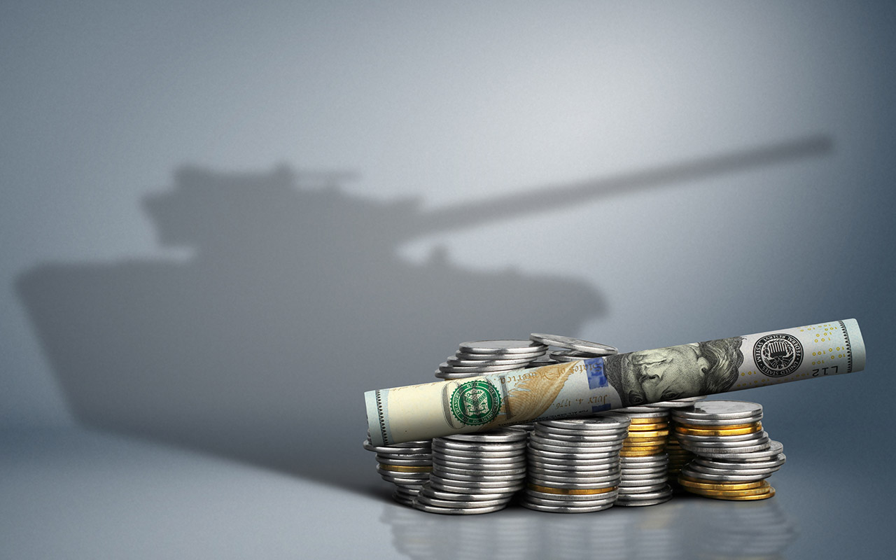 Coins stacked with a roll of cash on top