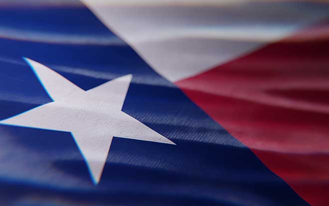 The Texas state flag fluttering in the wind, dramatic lighting