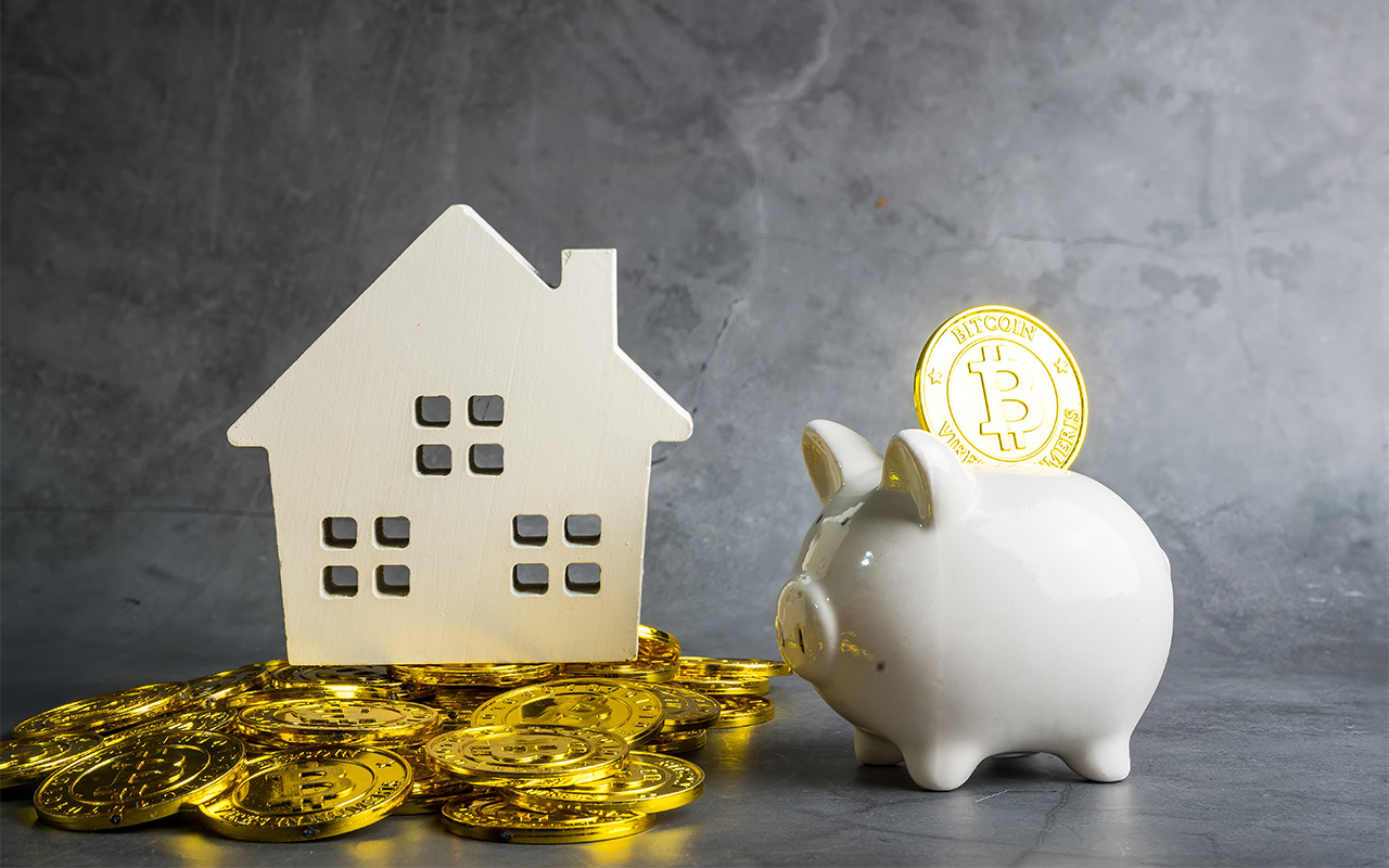 Bitcoin money with piggy bank and wooden home model on the table