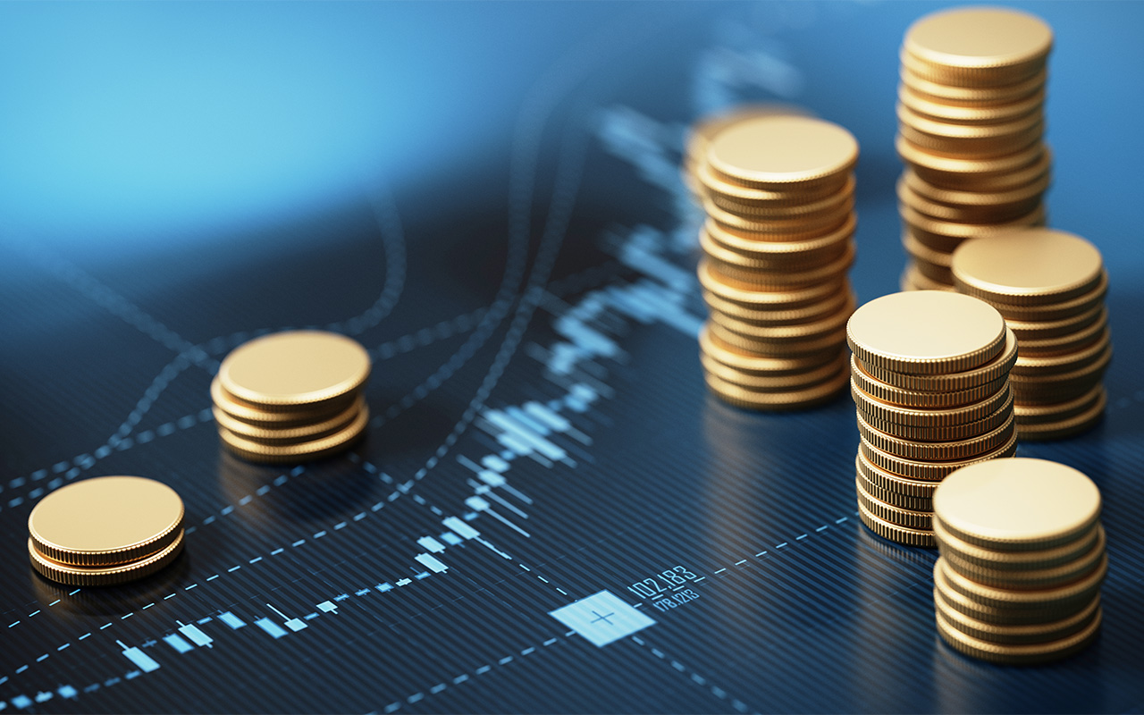 Coins sit on an electronic screen with a chart displayed.