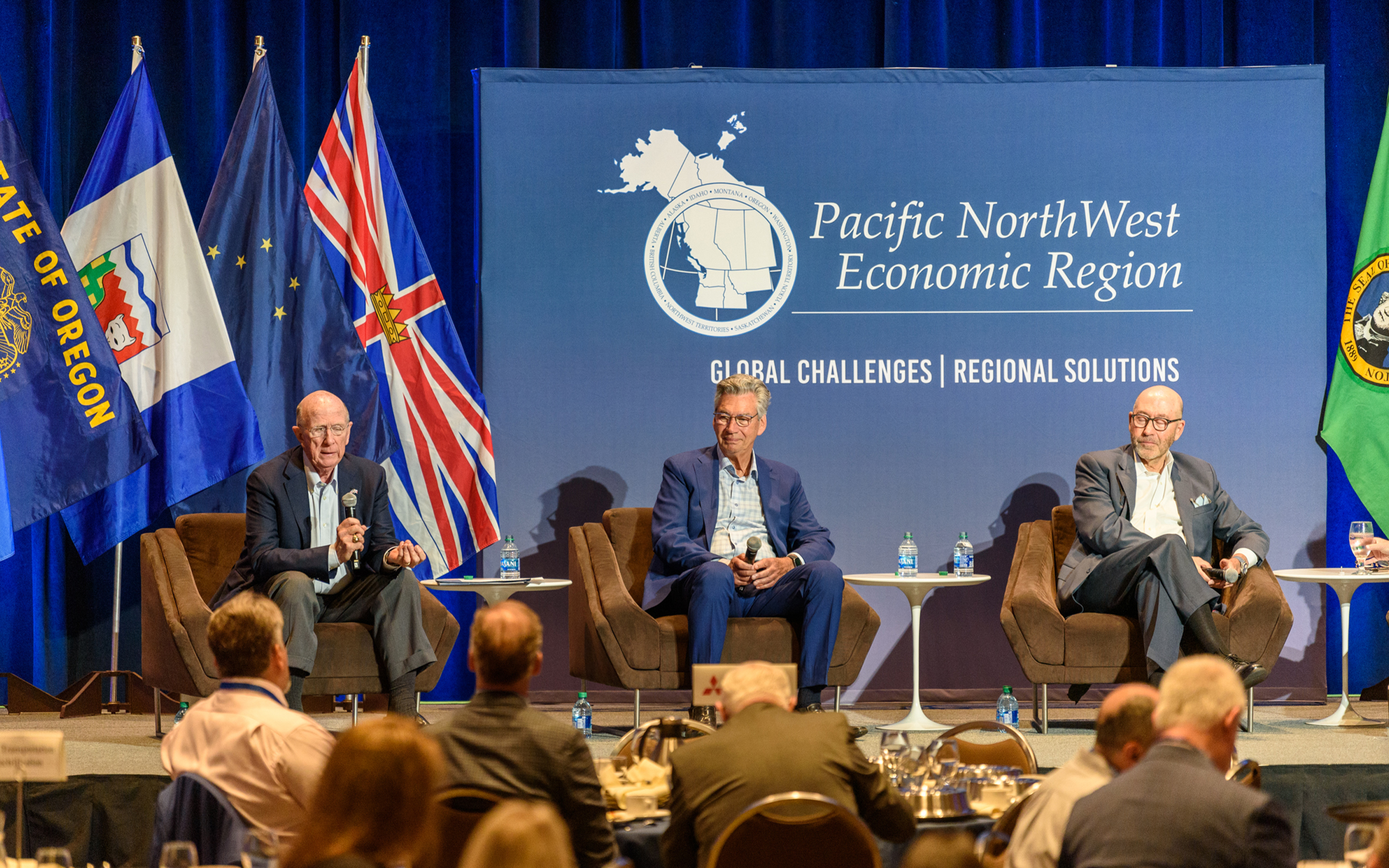Former ambassadors David Wilkins, Gary Doer, and David Jacobson sitting on a stage.