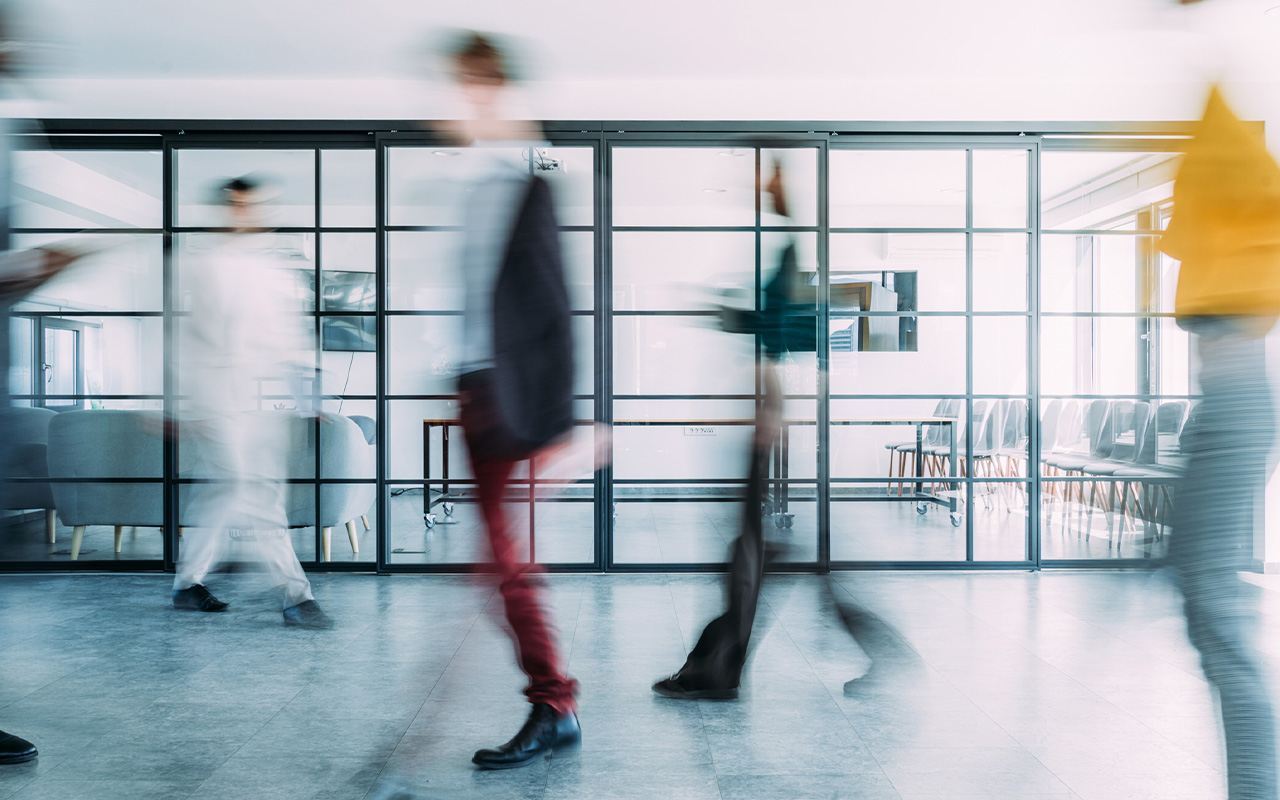 A group of people walking through a modern office space