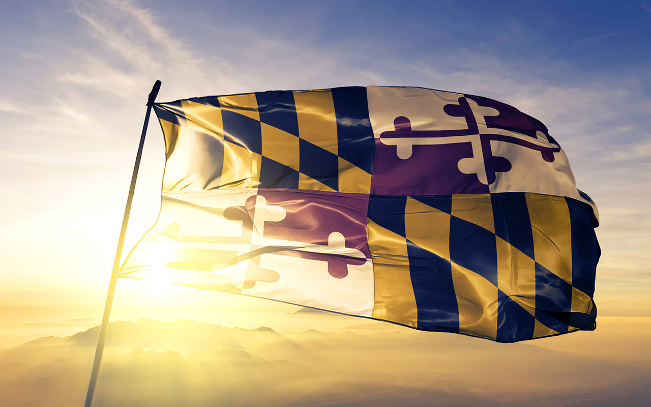 State of Maryland flag waves in front of a setting sun