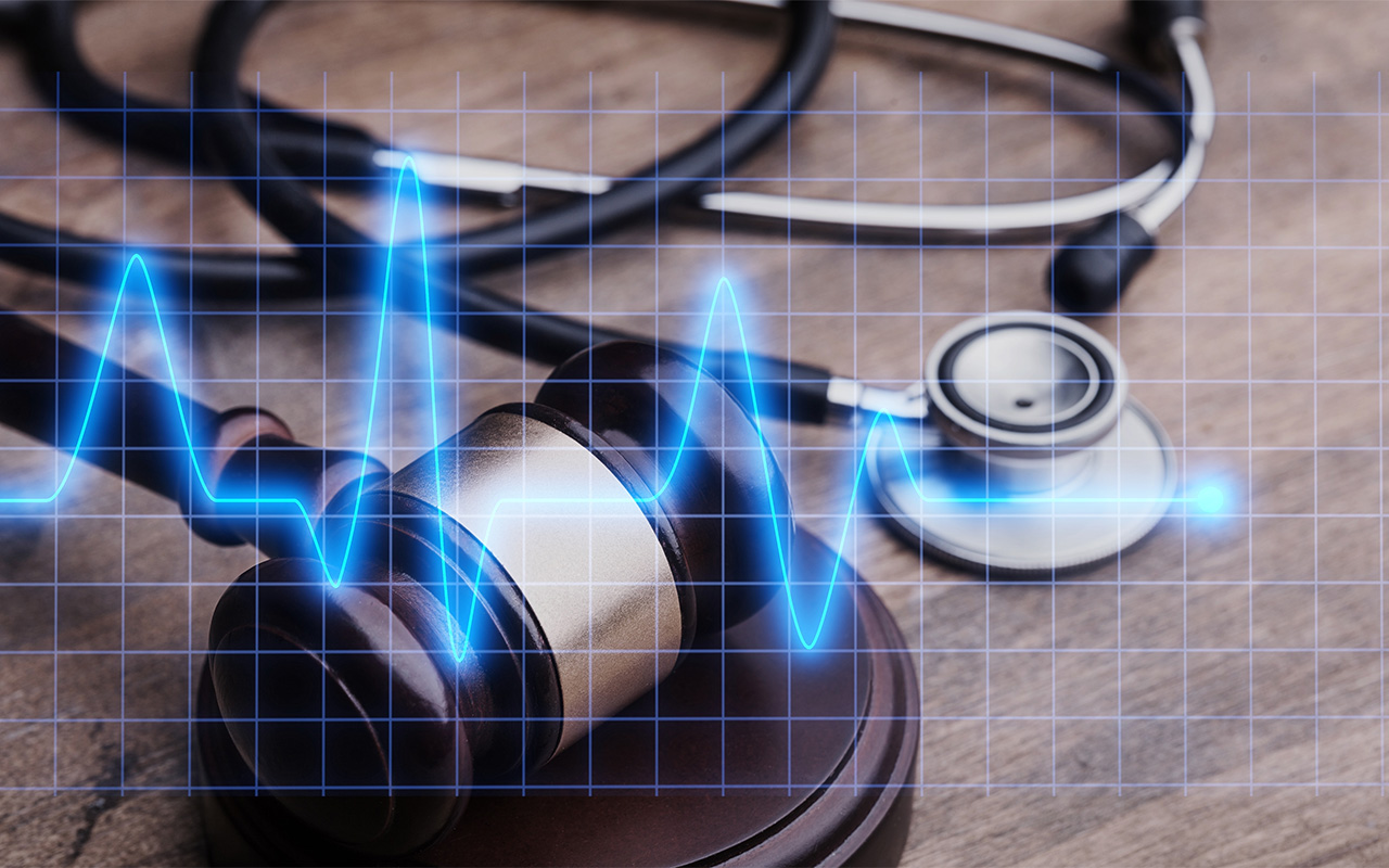Image of a stethoscope, heart monitor and gavel.