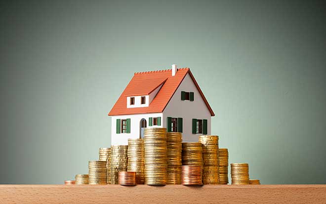 Image of a toy house surrounded by gold coins